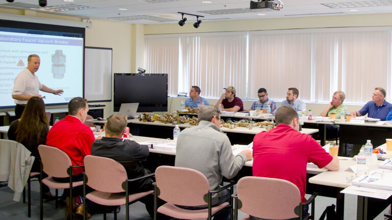 Lunch and Learn session, a man presenting information to a group at watts 